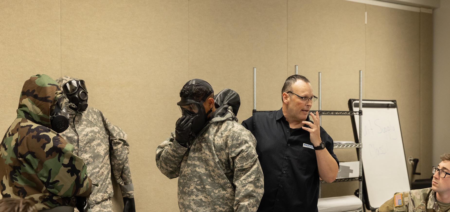 An instructor demonstrates mask safety in military programs